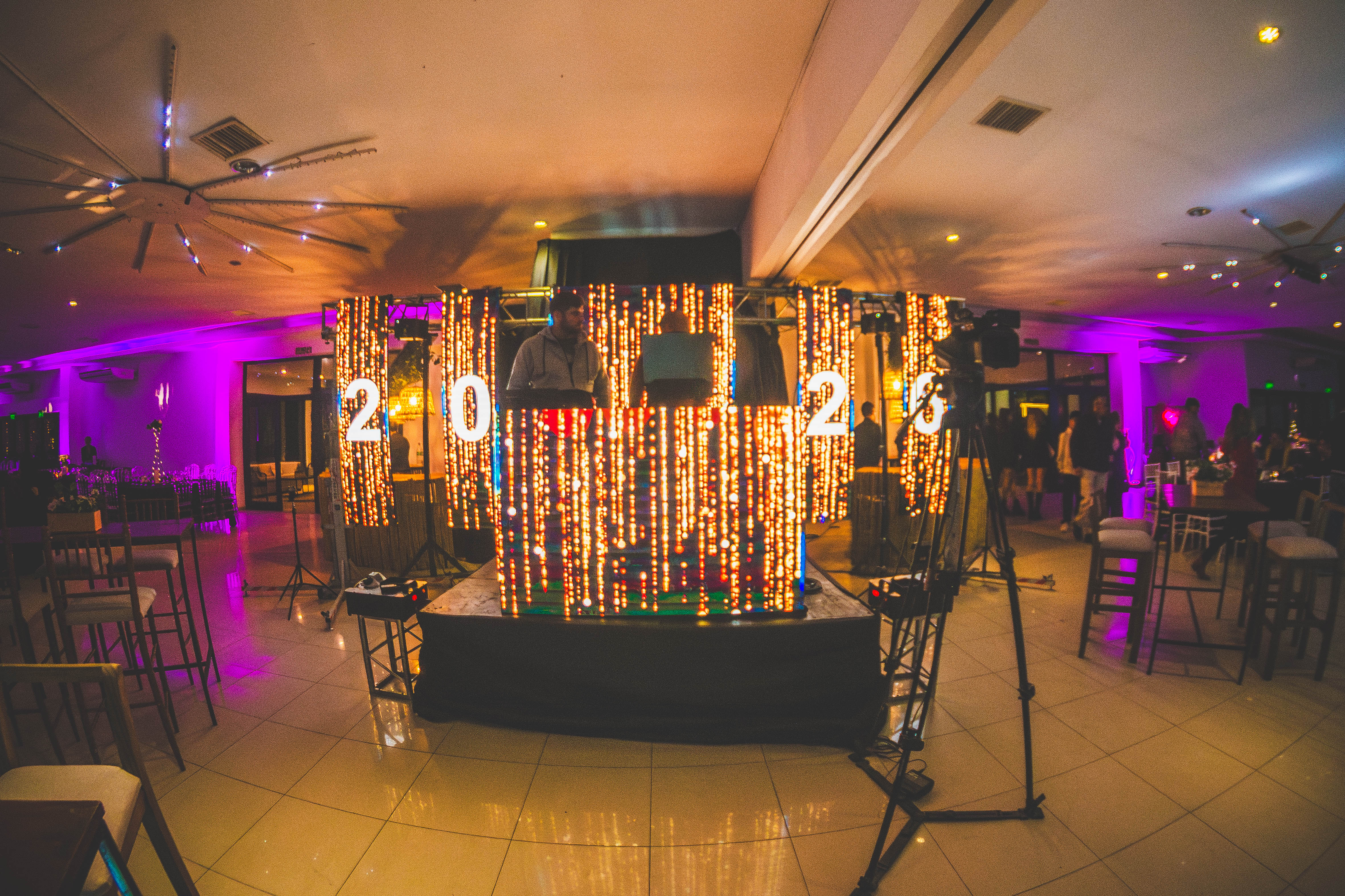 Montaje de iluminación decorativa en salón con cortinas de luces doradas